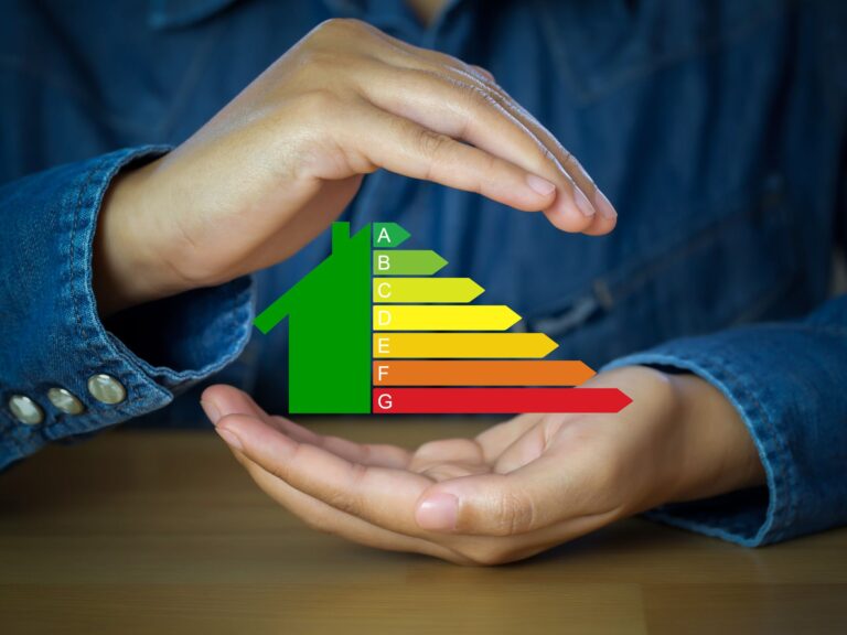 A pair of hands holding an energy efficiency chart in the shape of a house.